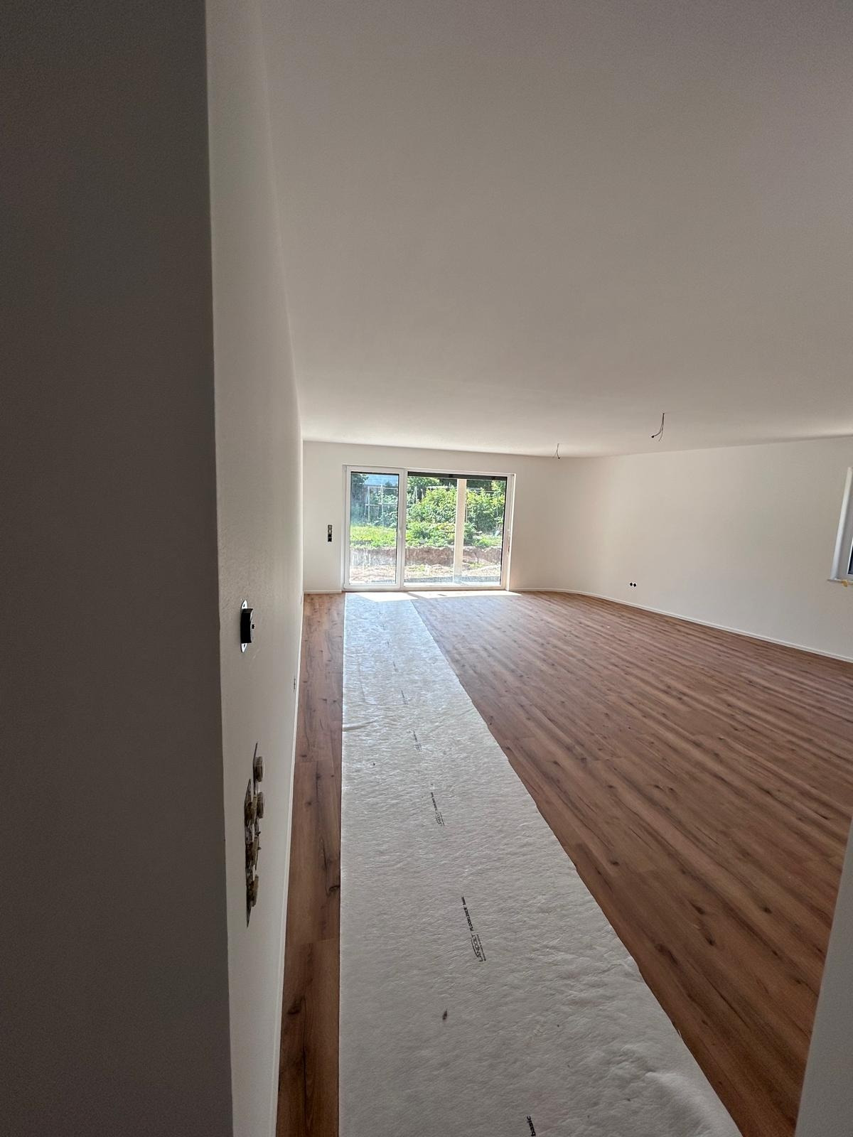 Wohnraum mit bodentiefen Fenstern nach dem Innenausbau