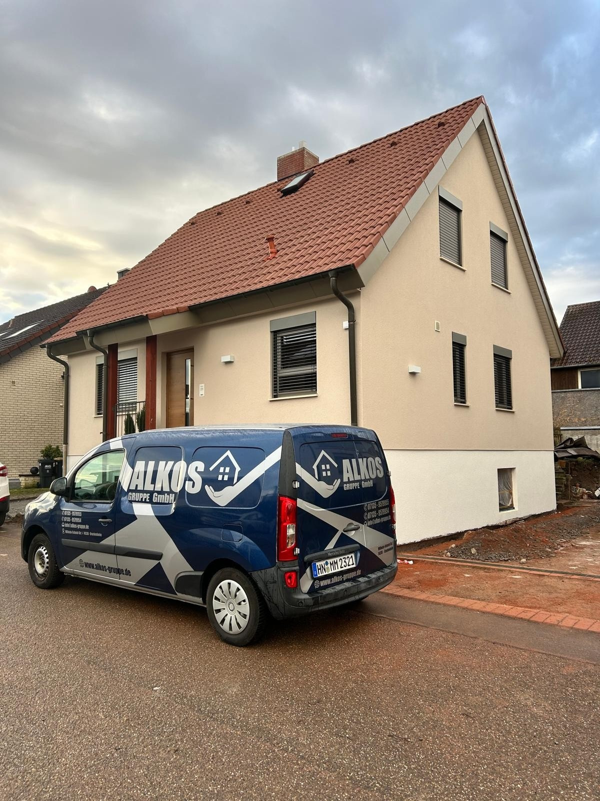 Wohnhaus nach der Fassadensanierung, mit Fahrzeug der ALKOS Gruppe