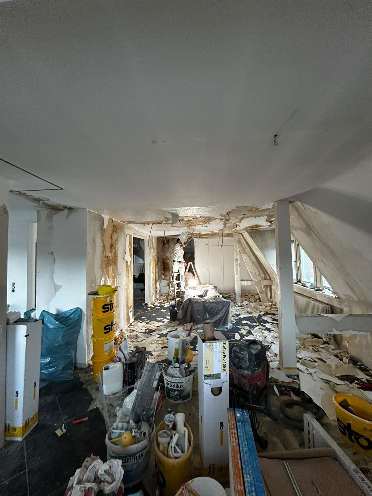 Dachgeschoss während der Entkernung, Material und Bauschutt im Raum